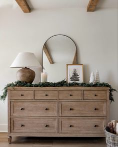 a dresser with christmas decorations and a mirror