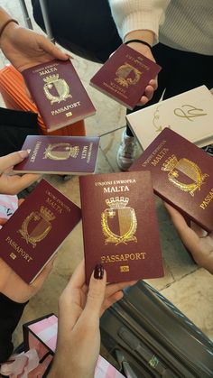 several people holding up their passports in front of the camera