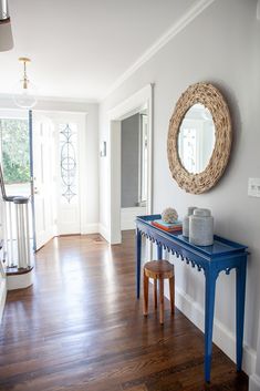 a blue console table sitting in the middle of a living room next to a doorway