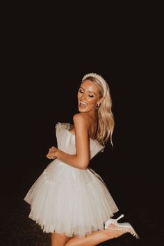 a woman in a white dress is posing for the camera with her legs spread out