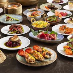 a table topped with plates filled with different types of foods and meats on top of it