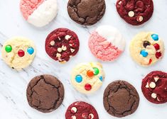 chocolate cookies and marshmallows are arranged on a marble surface