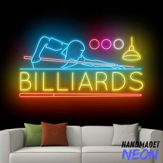 a neon sign that says billiards on the side of a wall next to a couch