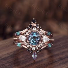 a fancy ring with an aqua blue stone surrounded by white and black diamonds on a wooden surface