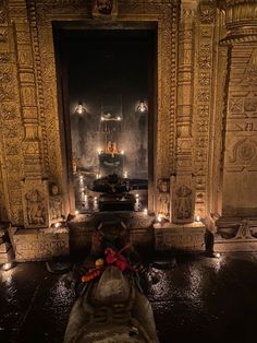 the interior of a temple with candles lit up