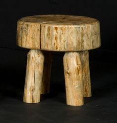 a small wooden stool sitting on top of a black surface