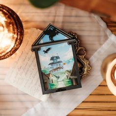 an image of a house with a bird on it next to a candle and some papers