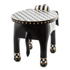 an elephant shaped stool with black and white checkers on it