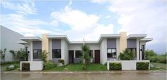 two story house with grass and shrubs in front