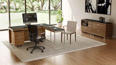 a desk with two chairs and a computer on it in front of a large window