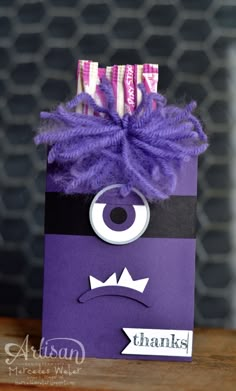 a purple bag that has some kind of monster face on it, and two candy sticks sticking out of it