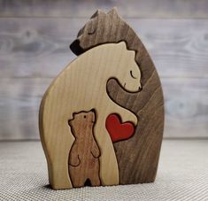 a wooden bear and bear cub holding a heart