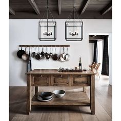 a kitchen island with pots and pans hanging from it's hooks on the wall