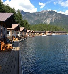 there is a boat dock on the water and mountains in the backgrouds