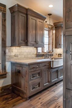 a large kitchen with wooden cabinets and white counter tops, wood flooring and an open door leading to another room