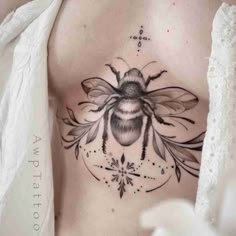 a woman's chest with a bee tattoo on it