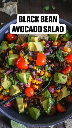 a black bean avocado salad in a bowl with a spoon on the side