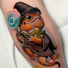 a lizard with a hat and book on his leg