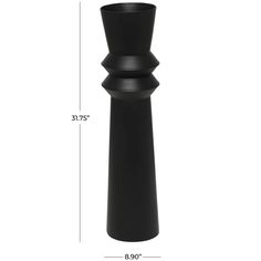 a tall black vase sitting on top of a white table next to a measuring ruler