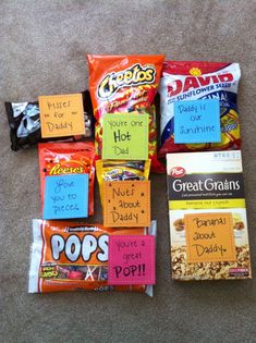 several bags of candy are on the floor with sticky notes attached to them, and there is also a bag of popcorn