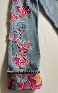 an old pair of jeans with flowers on them