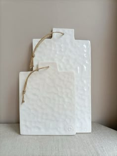 two white ceramic coasters with twine on them