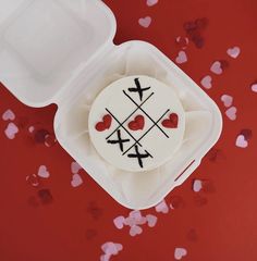 a cake in a plastic container with hearts on it