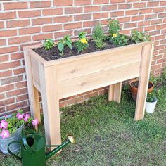 a wooden planter sitting on top of a grass covered field next to a brick wall