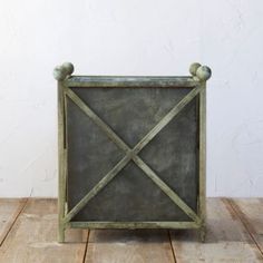 an old green metal box sitting on top of a wooden table next to a white wall