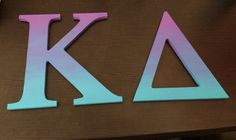 the letters k and l are cut out of wood with colored paper on top of them