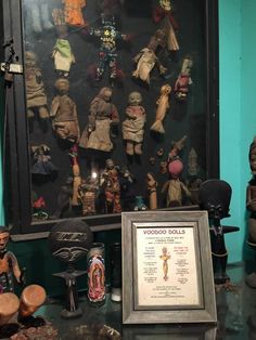 there are many small figurines on display in this room with a framed sign