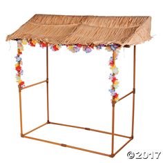 a small wooden structure with flowers on the sides and a thatch roof over it