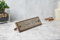 a wooden sign sitting on top of a table next to a potted plant