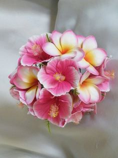 a bouquet of pink and white flowers sitting on top of a bed