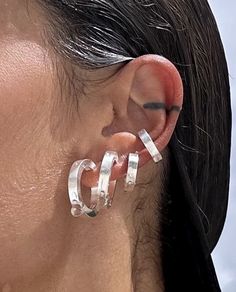 a close up of a person with ear piercings and an earring on their left side