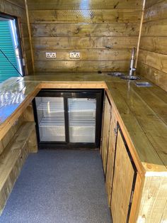 the inside of a small kitchen with wood paneling and stainless steel refrigerators in it