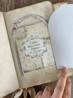 a hand is holding an old book with a mouse in it and the cover has been altered