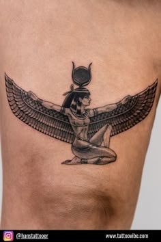 an egyptian tattoo design on the side of a woman's thigh, with wings and headdress