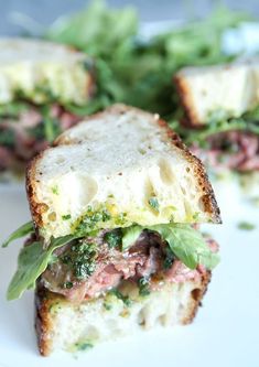 a close up of a sandwich on a plate with lettuce and other food