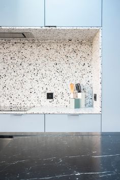 a kitchen counter top with various items on it and a sink in the middle, against a blue wall