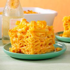 macaroni and cheese is stacked on two plates next to a bottle of water