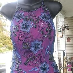 a mannequin wearing a purple dress with blue flowers on it's chest