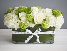 a vase filled with white and green flowers