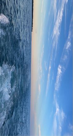 an airplane flying over the ocean on a sunny day