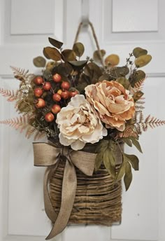 a basket filled with flowers sitting on top of a door