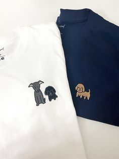 two t - shirts with embroidered dogs on them, one is blue and the other is white