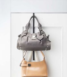 two purses hanging on the wall next to each other