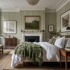 a bedroom with green and white wallpaper, a fireplace and pictures on the walls