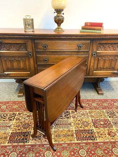 an antique desk and chair are sitting on the carpet in front of a large wooden dresser