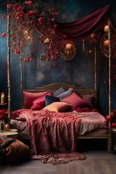 a bed with red sheets and pillows in a room decorated with flowers, candles and branches